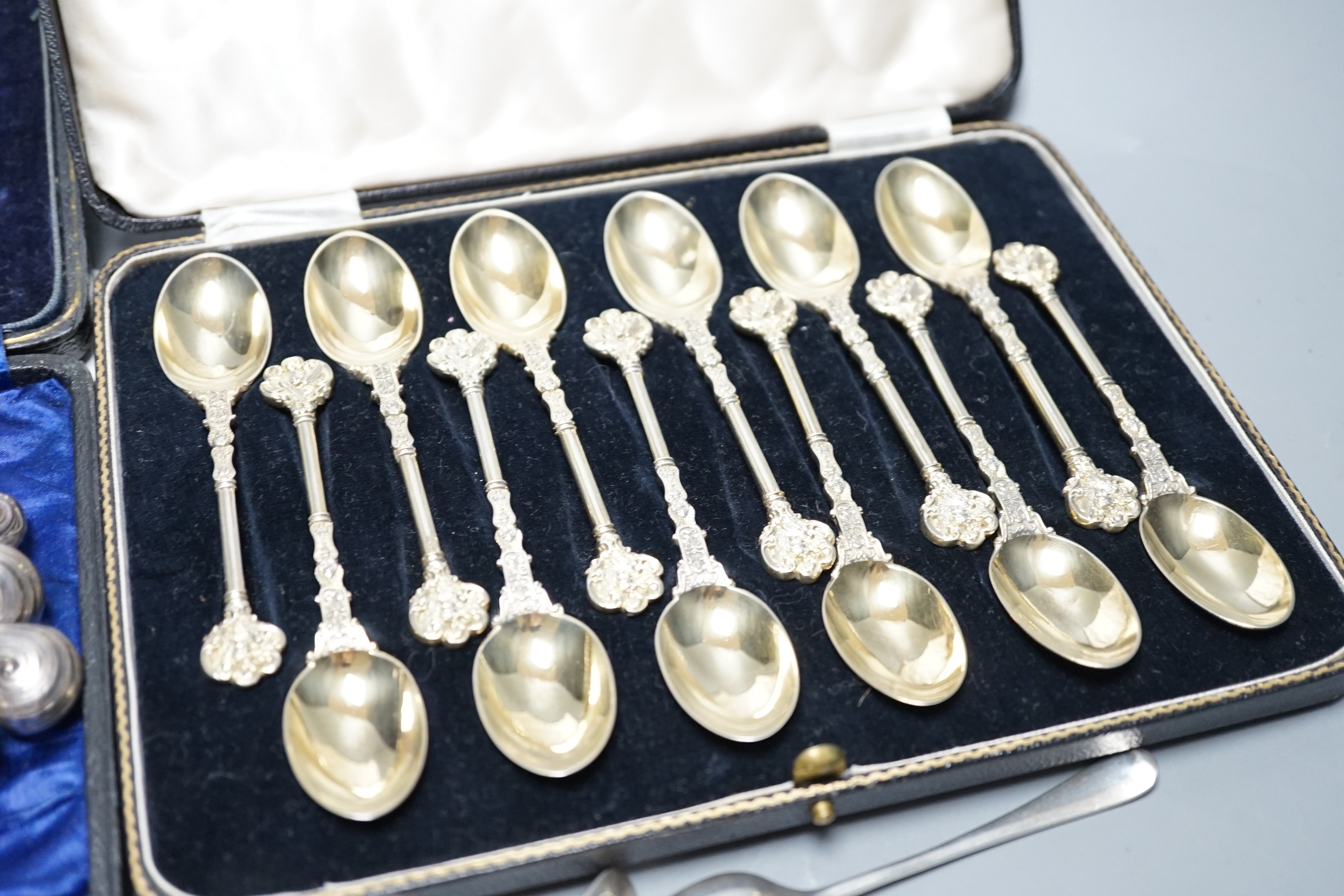 A cased set of twelve Victorian silver gilt teaspoons, London, 1894, six pairs of Edwardian silver pistol handled dessert eaters and four other forks, a set of six Malaysian white metal spoons, a set of six silver coffee